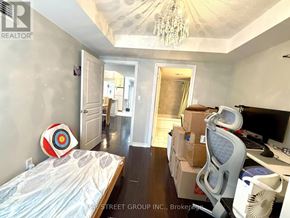 Toronto (Bay Street Corridor) condo for rent - A bedroom with a bed, desk, and chair with boxes on the floor.