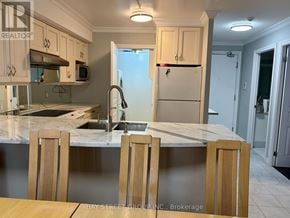 Toronto (Bay Street Corridor) condo for rent - A kitchen with a marble countertop and wooden chairs.