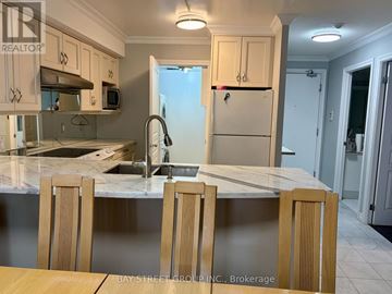 Toronto (Bay Street Corridor) condo for rent - A kitchen with a marble countertop and wooden chairs.