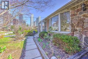 Toronto (St. Andrew-Windfields) apartment for rent - A house with a stone wall and a pathway leading to the front door.