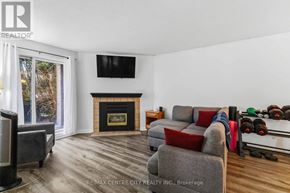 London East (East L) condo for rent - A living room with a grey couch, a fireplace, and a television.