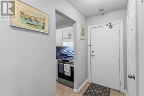 London East (East L) condo for rent - A small kitchen with a stove top oven and a painting on the wall.