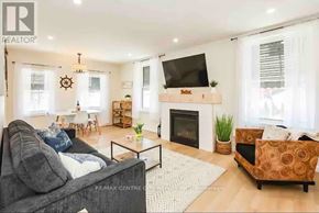 Central Elgin (Port Stanley) condo for rent - A living room with a grey couch, a fireplace, and a television.
