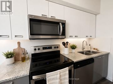 Waterloo condo for rent - A modern kitchen with a black oven and white cabinets.