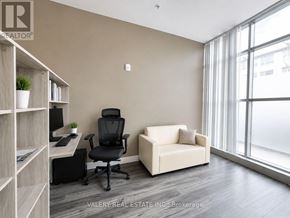 Waterloo condo for rent - A room with a desk, chair, and couch with a window in the background.