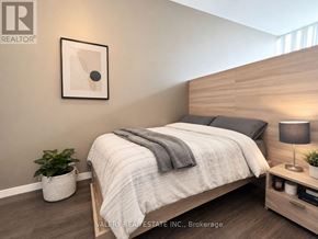 Waterloo condo for rent - A bedroom with a bed, nightstand, and lamp.