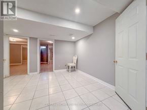 Markham (Middlefield) apartment for rent - A white chair is placed in the middle of a white tiled room.