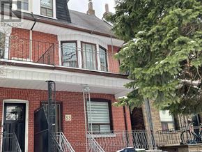 Toronto (Danforth) apartment for rent - A red brick house with a black door and a black gate.