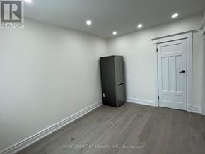 Toronto (Danforth) apartment for rent - A room with a black fridge and a white door.