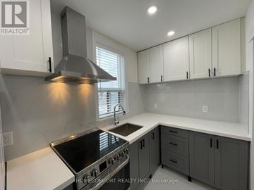 Toronto (Danforth) apartment for rent - A modern kitchen with a stove top oven and a range hood.