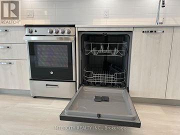 Hamilton (Corktown) house for rent - A modern kitchen with a stainless steel oven and a dishwasher.