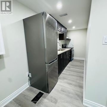 Mississauga (Creditview) apartment for rent - A stainless steel refrigerator in a kitchen with wooden flooring.