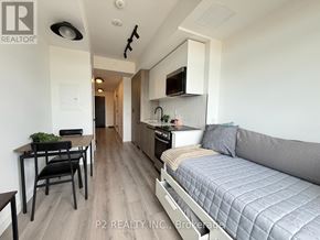 Toronto (Centennial Scarborough) condo for rent - A modern kitchen with a grey couch and a dining table.
