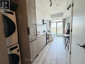 Toronto (Centennial Scarborough) condo for rent - A modern kitchen with wooden cabinets and a washing machine.