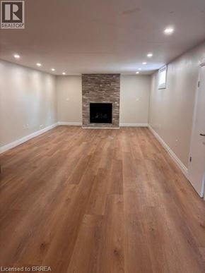 Brantford apartment for rent - A spacious room with wooden flooring and a stone fireplace.