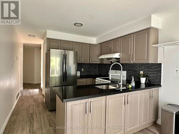 Mississauga (Fairview) apartment for rent - A kitchen with a black counter top and wooden cabinets.