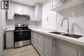 Kitchener apartment for rent - A modern kitchen with white cabinets and stainless steel appliances.