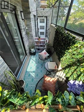 Kitchener triplex for rent - A balcony with a table and chairs surrounded by plants.