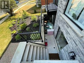 Kitchener triplex for rent - A balcony with a black railing and a small table with a red object on it.