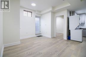Kitchener apartment for rent - A room with white walls and wooden flooring, with a window and a door visible.