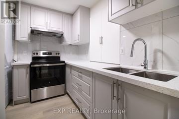 Kitchener apartment for rent - A modern kitchen with white cabinets and stainless steel appliances.
