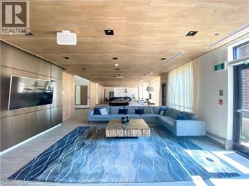 Grimsby condo for rent - A spacious living room with a long blue rug and a wooden ceiling.