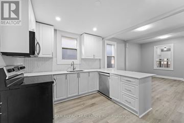 Hamilton (Industrial Sector) apartment for rent - A kitchen with white cabinets and a black stove top oven.