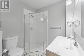 Hamilton (Industrial Sector) apartment for rent - A white bathroom with a glass shower stall and a toilet.