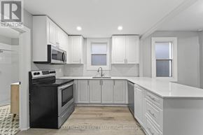 Hamilton (Industrial Sector) apartment for rent - A kitchen with black appliances and white cabinets.