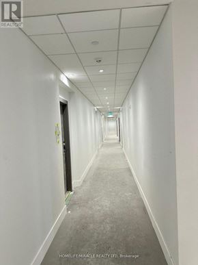Clarington (Bowmanville) condo for rent - A long, narrow hallway with white walls and a grey carpet.