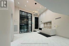 Clarington (Bowmanville) condo for rent - A white interior space with a black door and a white reception desk.