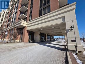 Markham (Wismer) condo for rent - A large building with a covered walkway in front of it.