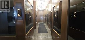 Markham (Wismer) condo for rent - A hallway with a carpeted floor and a series of doors on both sides.