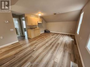 Markham (Wismer) apartment for rent - A spacious room with wooden flooring and a kitchen area in the background.