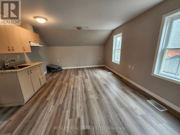 Markham (Wismer) apartment for rent - A room with wooden flooring and a kitchen area with cabinets and a sink.