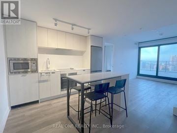 Hamilton (Beasley) condo for rent - A modern kitchen with white cabinets and a large island.