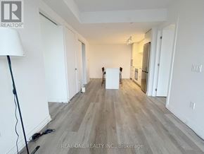 Hamilton (Beasley) condo for rent - A room with white walls and wooden flooring, with a lamp on the left and a white box in the middle.