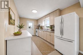Guelph (St. George's) apartment for rent - A white refrigerator is in a kitchen with wooden cabinets.