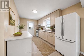 Guelph (St. George's) apartment for rent - A white refrigerator is in a kitchen with wooden cabinets.