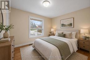 Guelph (St. George's) apartment for rent - A bedroom with a large bed, a window, and a painting on the wall.