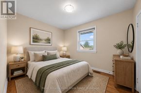 Guelph (St. George's) apartment for rent - A bedroom with a bed, nightstand, and a window with a view of a tree.