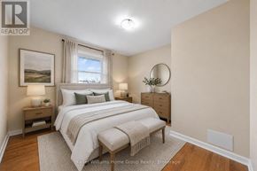 Guelph (St. George's) apartment for rent - A well-lit bedroom with a large bed and a painting on the wall.