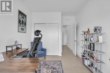 Guelph (St. Patrick's Ward) condo for rent - A living room with a blue chair and a wooden table.