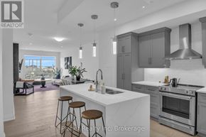 Guelph (St. Patrick's Ward) condo for rent - A modern kitchen with a large island and stainless steel appliances.