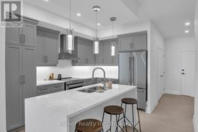 Guelph (St. Patrick's Ward) condo for rent - A modern kitchen with a large island and stools.