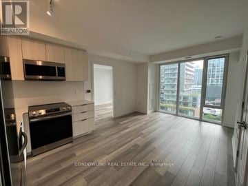 Toronto (Moss Park) condo for rent - A modern kitchen with a stove top oven and microwave.