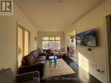 Brampton (Fletcher's Meadow) apartment for rent - A living room with a brown leather couch and a flat screen TV mounted on the wall.