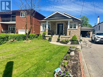 Toronto (Maple Leaf) apartment for rent - A house with a well-maintained lawn and a car parked in the driveway.