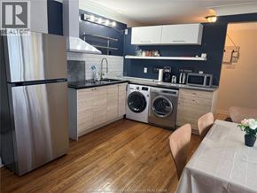 Windsor apartment for rent - A kitchen with a refrigerator, washing machine, and microwave.