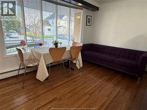Windsor apartment for rent - A room with a purple couch and a table with chairs.